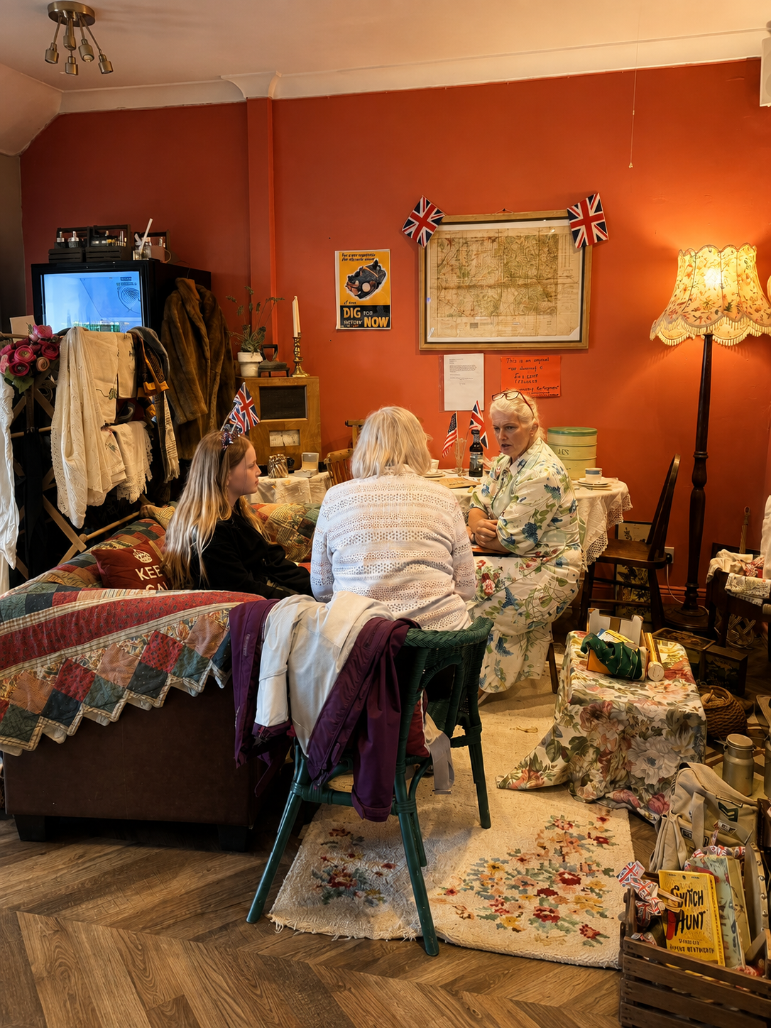 Inside Low Tide Coffee House with a warm red dining room, vintage map and guests enjoying tea